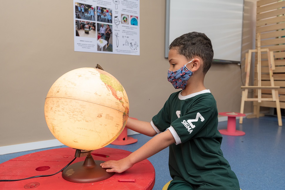Criança explorando o globo terrestre