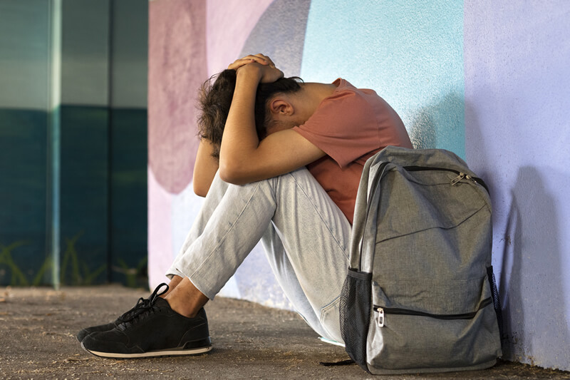 full shot sad boy sitting ground 1
